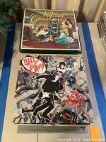 Photo showing two album covers: a Christmas-themed album and a rock-themed album with graffiti-style artwork and autographs.