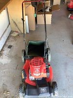 Full view of the Craftsman M230 lawn mower showing red deck, handlebar, grass catcher bag and wheels.