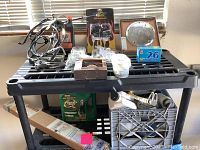 Photo of a black plastic shelf with Harley-Davidson motorcycle parts and accessories arranged on top and underneath.