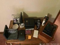 Photo showing Harley Davidson bookends, jewelry boxes, perfume bottles, shoe polish, and small containers on a wooden surface.