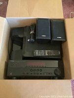 Yamaha AV receiver, two bookshelf speakers, remote control, center and subwoofer speakers packed in a box