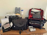 All items arranged showing camcorder, cameras, Garmin GPS, printer dock and carrying bags.