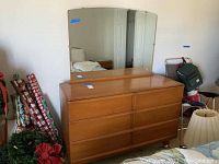 Full front view of wood dresser with removable mirror attached, showing six drawers and clean surface.