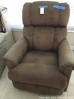 Front view of brown La-Z-Boy rocker recliner showing cushioned armrests and backrest.