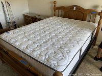 Photo of queen size bed assembled with mattress, headboard, footboard, and frame visible