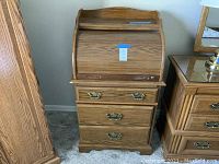 Front view of the oak finish roll top desk showing brass handles and tambour door with lock cylinder.