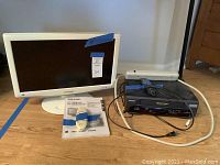 Sharp white 18-inch LCD television with remote and VHS player on wooden floor