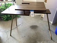 Full view of folding sewing machine table with metal legs on concrete floor