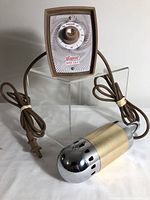 Full view of the Niagara Hand Unit massager showing the chrome and beige handheld unit connected by a brown cord to the control box with power cord.
