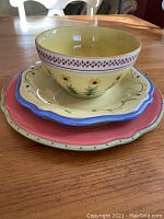 Stacked bowl, salad plate, and dinner plate showing colors and scalloped edges.