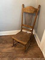 Full view of wooden rocking chair showing seat, rockers, and backrest details.