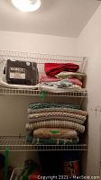 Shelf with bamboo sheet set, folded bath mats, fleece blankets