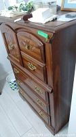 Front and side view of wood highboy style dresser showing drawers, door storage, brass pulls, and scratches.