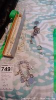 Overview of two pearl necklaces, two charm bracelets and two rings laid out on patterned surface