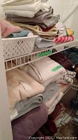 Shelving with folded bath towels, hand towels, and baby blankets in various colors and textures