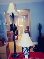 Photo showing faux ginger jar ceramic table lamp with floral pattern and fabric shade, and walnut wood look standing lamp with visible crack.