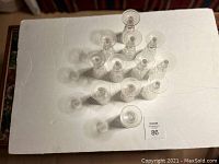 Photo from above showing all 12 crystal sherry glasses arranged close together on a white cloth.