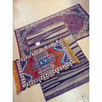Photo showing the three rugs laid overlapping on a light floor, displaying their distinct patterns and sizes.
