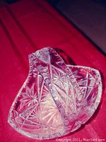 Close-up of crystal basket showing detailed starburst and geometric cut patterns with a sturdy handle.