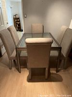 Front view of full dining table and six chairs against wall