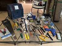 Full view of assorted hand tools and accessories placed on glass table