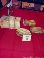 Five onyx decorative pieces on red cloth: 2 rectangular block bookends, 2 oval soap dishes, 1 file holder with slot.