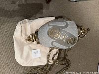 Photo showing the large swag lamp with ornate frosted glass and gold floral design, metal fixtures and hanging chain.