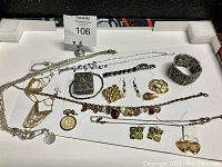 Full view of assorted jewelry pieces including rings, bracelets, necklaces, and earrings displayed flat