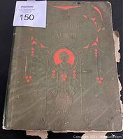 Front cover of the antique postcard album showing embossed title and red decorative design