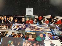 Wide display of assorted celebrity photos spread on a surface with black background, showing variety of people and moments captured.