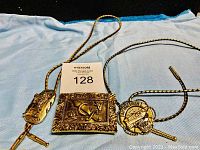 Image showing three metal Shriners regalia items including two bolo ties and a rectangular pendant.