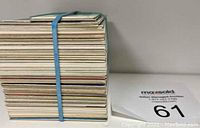 Side view of a thick stack of baseball cards held together by a rubber band showing card edges and thickness.