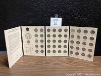 Collector book with three open panels showing most of the commemorative quarters in place along with introductory info page visible.