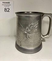 View of the full pewter stein showing the dragon engraving and handle shape