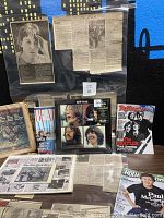 Photo showing sealed Beatles "Let It Be" album and various Beatles magazines, newspaper clippings, and laminated articles.
