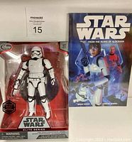 Photo showing Star Wars Elite Series First Order Stormtrooper Officer die-cast action figure in box alongside Star Wars Volume Two graphic novel.