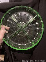 Top-down view of the vintage Vaseline glass candy dish showing four compartments and scalloped edge.