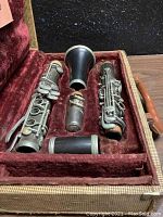 Overall view of vintage Selmer clarinet disassembled in original case with red velvet interior and handle.