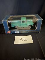 Front view of the green 1955 Chevy 3100 Stepside die cast model in original blue box with plastic display window showing the truck inside.