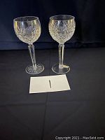 Two crystal Waterford goblets on black background, showing different cut patterns and starburst bases.