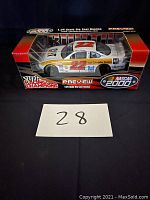 Side view of car in original box showing number 22, CAT branding, and packaging with Racing Champions and NASCAR 2000 logos.