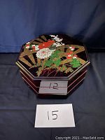 Stacked view of the octagonal Chinese serving container showing the colorful floral and fan decorations on the top and sides