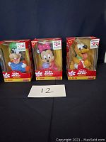 Front view of three boxed Disney Baby Mickey Squeezies figures including Goofy, Minnie Mouse, and Pluto character figures suitable for babies aged 3-24 months.