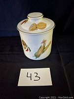 Royal Worcester biscuit jar showing painted vegetables such as corn and lemons on the side and top of the lid.