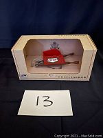 Steel wheelbarrow model inside original box with CO-OP logo on the side and visible window opening on front of box.