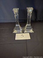 Pair of clear crystal candlesticks with square bases and a faceted geometric design