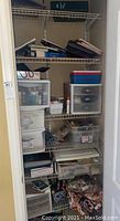 Full view of closet shelves filled with assorted arts and crafts supplies, plastic drawers, baskets, and boxes
