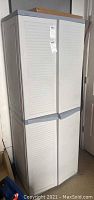 Front view of one closed Black and Decker plastic storage cabinet, beige with slatted doors and gray trims.