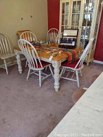 View of full dining table set with oak top and four chairs around it.