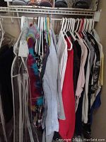 Photo showing a rack of women's tops and sweaters including tie-dye, striped cardigans, solid colors, and patterned pieces mainly in sizes large and extra large.